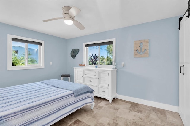 14124 Kulig Ct, Hudson, FL 34667 - bedroom featuring a ceiling fan, baseboards, and a barn door