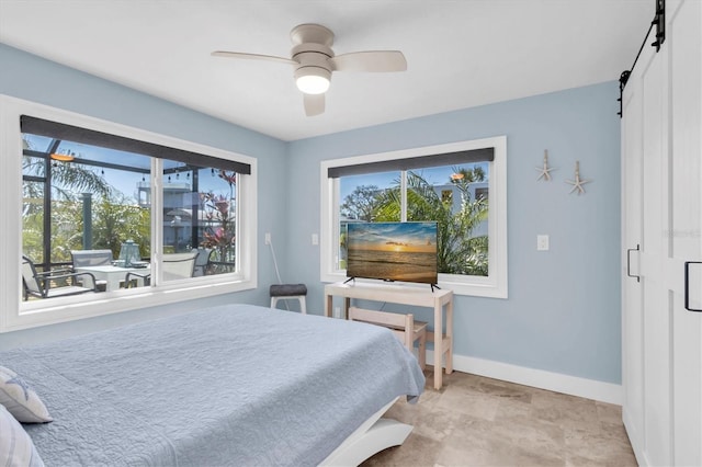 14124 Kulig Ct, Hudson, FL 34667 - bedroom featuring a barn door, baseboards, and ceiling fan