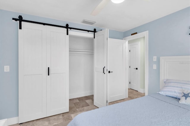 14124 Kulig Ct, Hudson, FL 34667 - bedroom featuring ceiling fan, a barn door, a closet, and visible vents