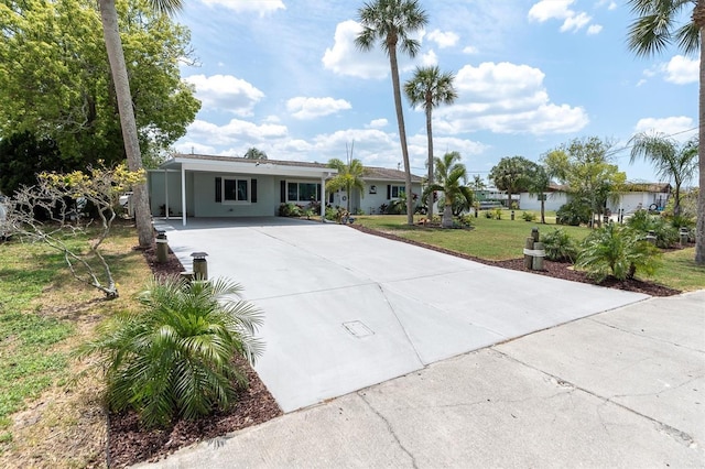 14124 Kulig Ct, Hudson, FL 34667 - view of front of home with driveway, an attached carport, a front yard, and stucco siding