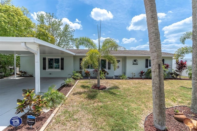 14124 Kulig Ct, Hudson, FL 34667 - ranch-style house with an attached carport, driveway, a front lawn, and stucco siding