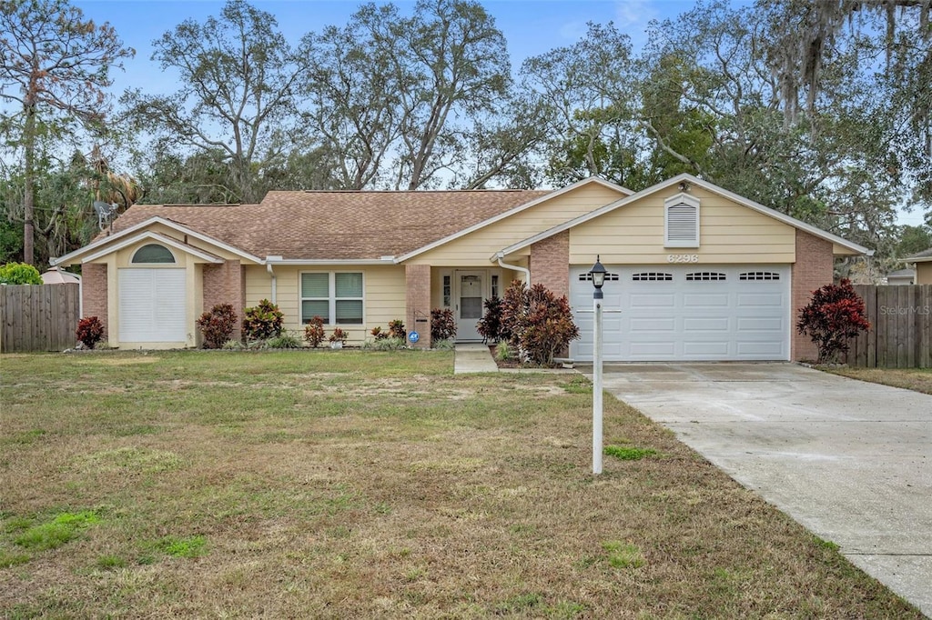 single story home featuring a garage and a front lawn