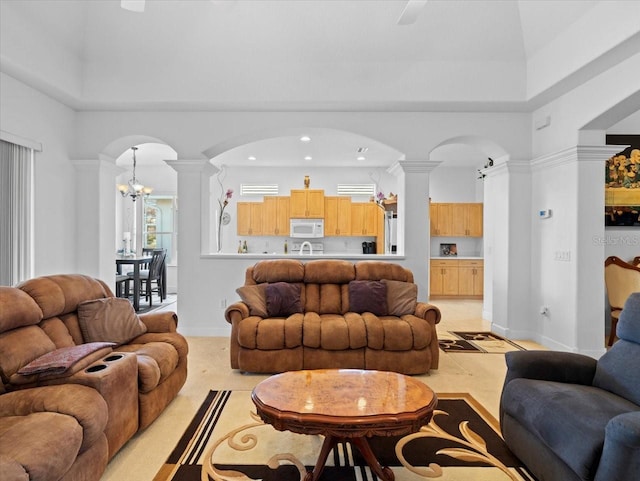 living room with sink, a towering ceiling, and ornate columns