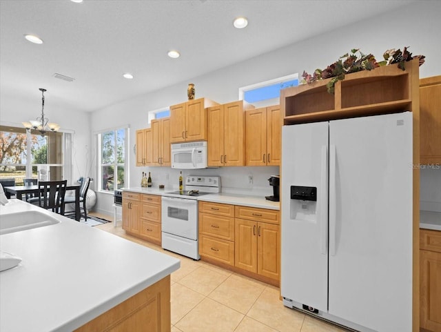 kitchen featuring sink, hanging light fixtures, light tile patterned floors, white appliances, and an inviting chandelier