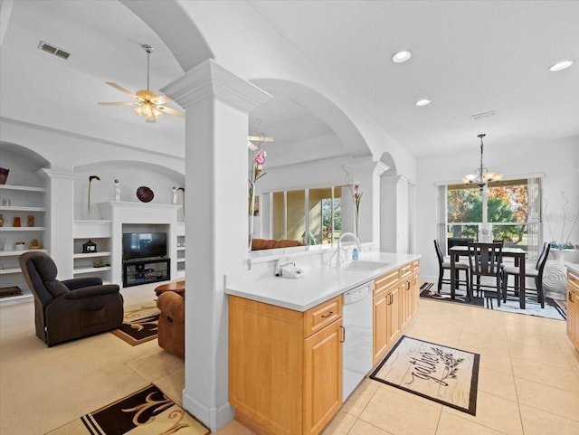 kitchen featuring built in features, decorative columns, dishwasher, sink, and light brown cabinets