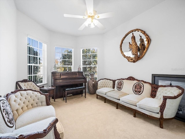 sitting room with ceiling fan and light carpet