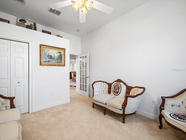 sitting room with light carpet, ceiling fan, and french doors