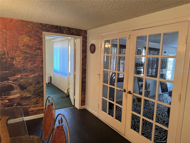 doorway to outside with a textured ceiling and french doors