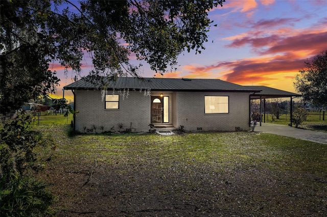 view of front of house featuring a lawn and a carport