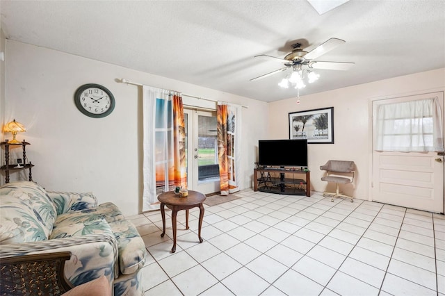 living room featuring a textured ceiling, a wealth of natural light, ceiling fan, and light tile patterned flooring