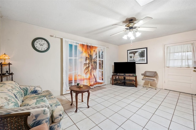 living room featuring ceiling fan, a textured ceiling, and light tile patterned floors