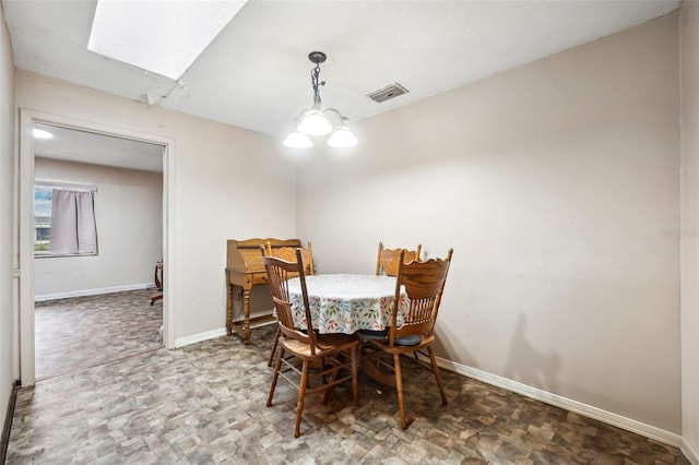 dining room featuring a skylight