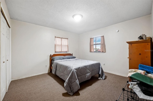 bedroom featuring a closet, a textured ceiling, and carpet flooring