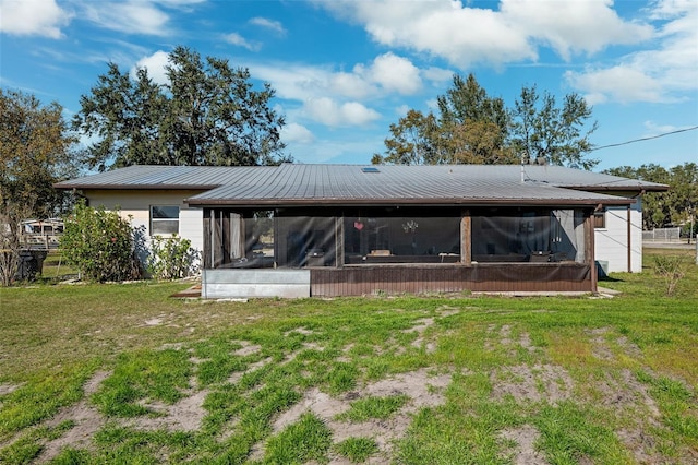 rear view of house with a yard and a sunroom