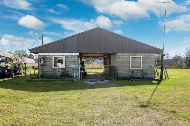 view of side of property featuring an outbuilding and a lawn