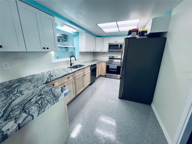 kitchen featuring white cabinetry, light stone countertops, appliances with stainless steel finishes, and sink