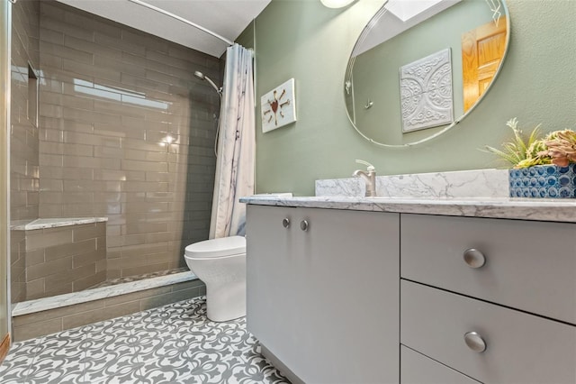 bathroom with vanity, curtained shower, tile patterned floors, and toilet