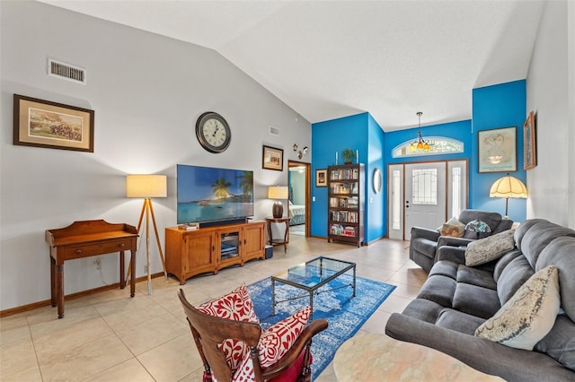 tiled living room with an inviting chandelier and vaulted ceiling