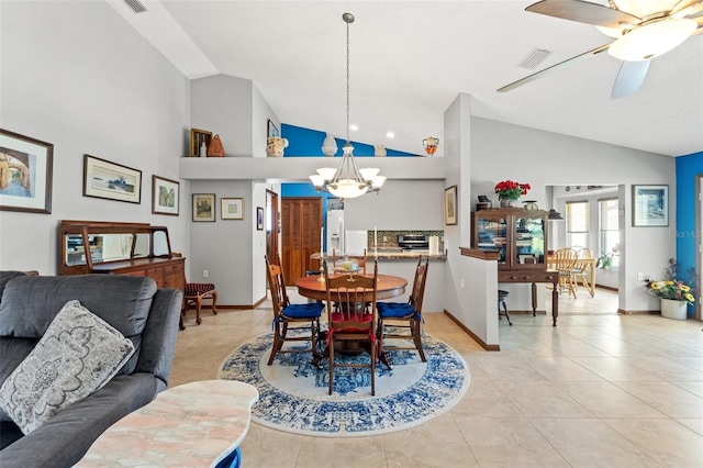 dining room with vaulted ceiling, ceiling fan with notable chandelier, and light tile patterned floors