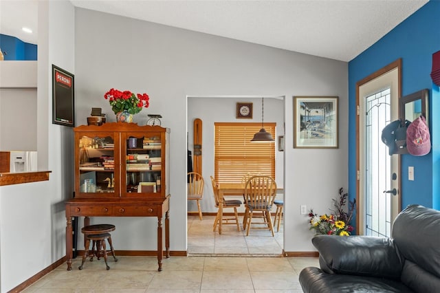 interior space featuring light tile patterned flooring and vaulted ceiling