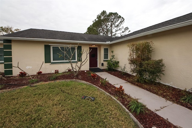 view of exterior entry with a lawn