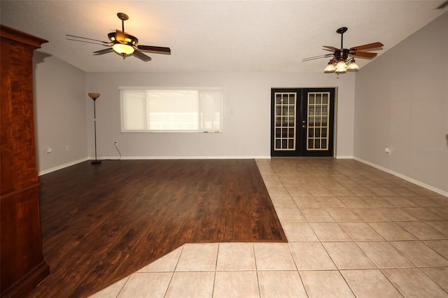 tiled empty room with a textured ceiling, french doors, and ceiling fan