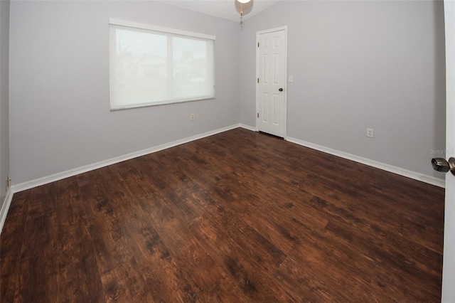 empty room with lofted ceiling and dark hardwood / wood-style flooring