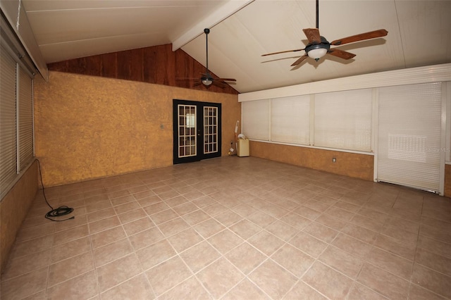 interior space featuring lofted ceiling with beams, french doors, ceiling fan, and wood walls