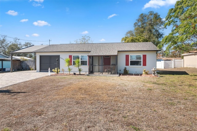 single story home with a garage, a front yard, and a sunroom