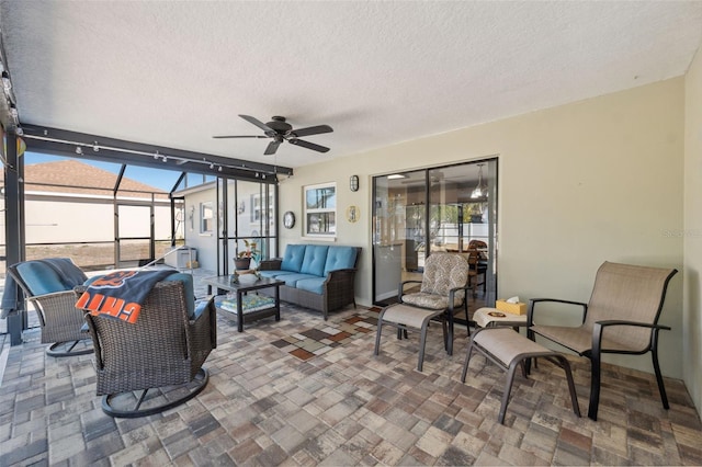 view of patio featuring a lanai, outdoor lounge area, and ceiling fan