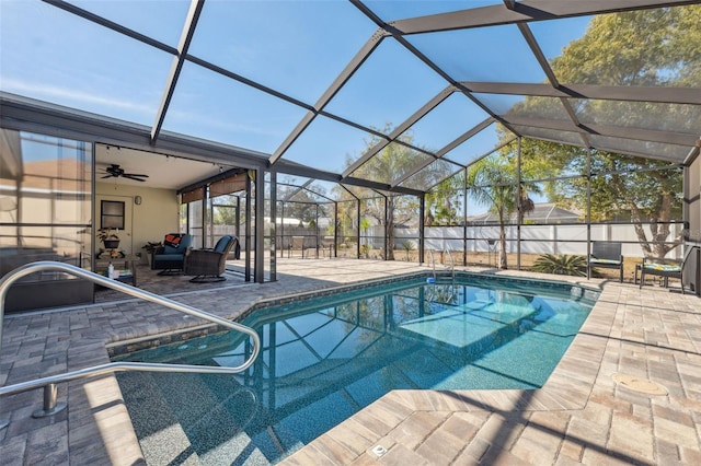 view of swimming pool with a patio, ceiling fan, and glass enclosure