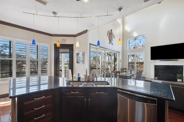 kitchen featuring sink, dark brown cabinets, a textured ceiling, stainless steel dishwasher, and pendant lighting