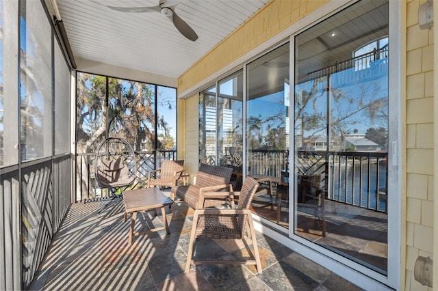 unfurnished sunroom with ceiling fan