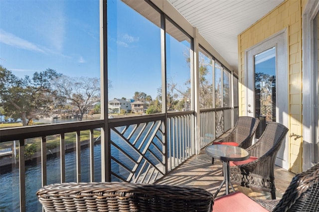 sunroom featuring a water view