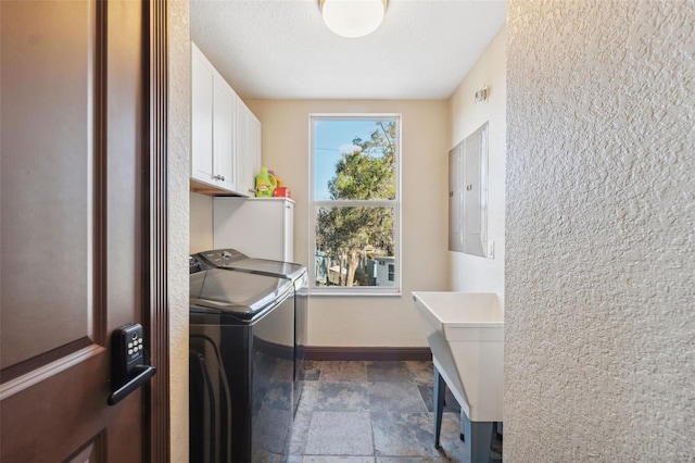 washroom with cabinets, washer and clothes dryer, sink, and a textured ceiling