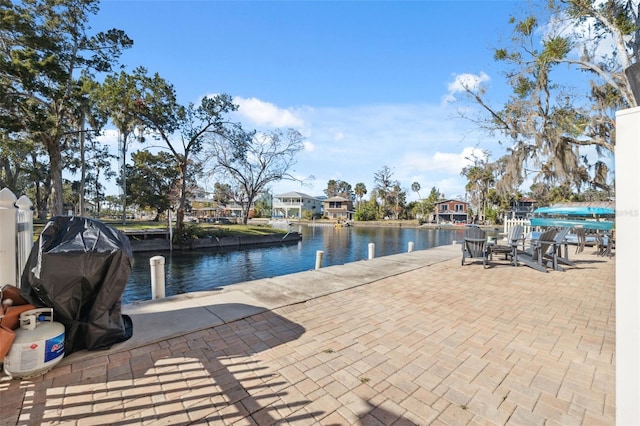 exterior space featuring a grill, a boat dock, and a water view