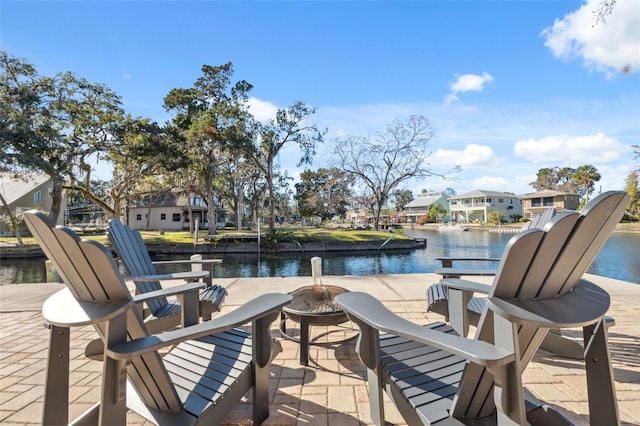 view of patio with a water view and an outdoor fire pit