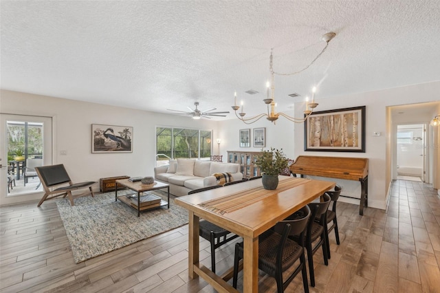 dining room featuring hardwood / wood-style flooring, a textured ceiling, and a healthy amount of sunlight