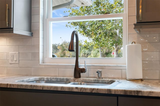 details with light stone countertops, sink, and decorative backsplash