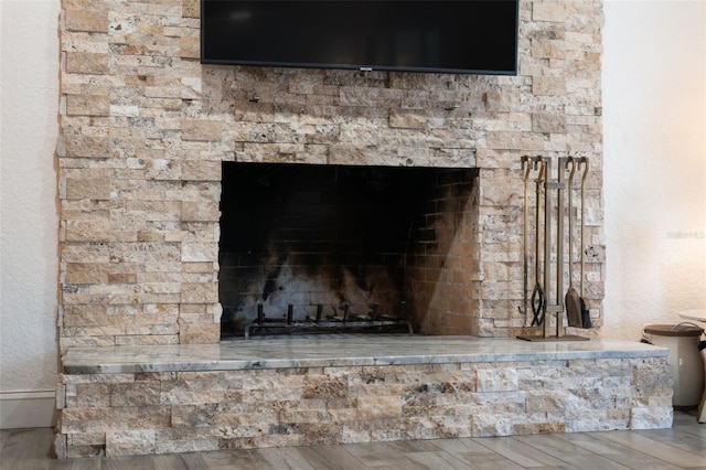 room details with a stone fireplace and hardwood / wood-style floors