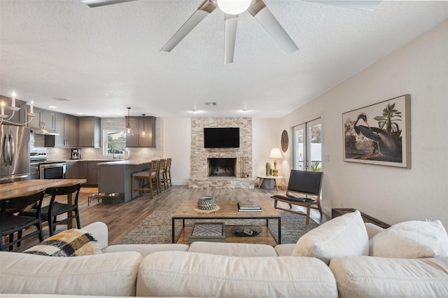 living room featuring a fireplace, a healthy amount of sunlight, dark hardwood / wood-style floors, and sink