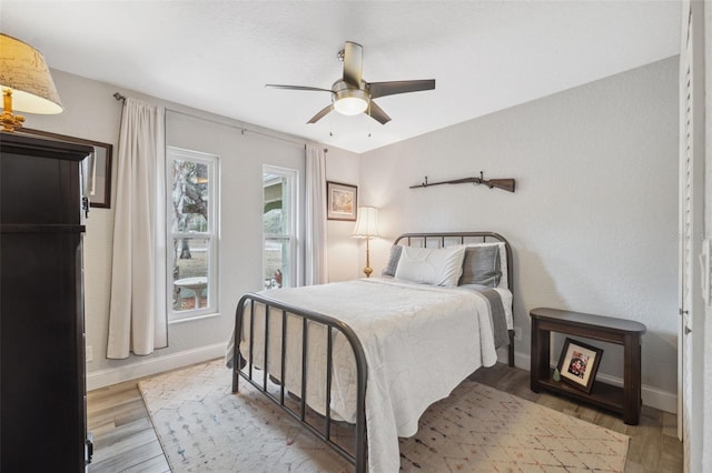 bedroom with ceiling fan and light hardwood / wood-style floors