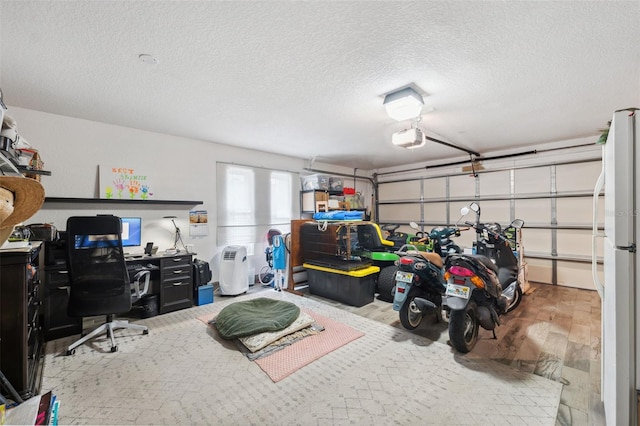 garage featuring white refrigerator and a garage door opener