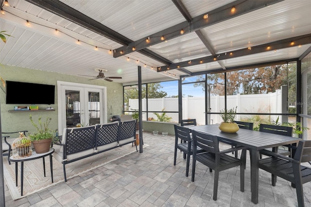 sunroom / solarium featuring french doors, ceiling fan, and beam ceiling