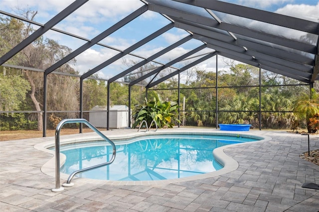 view of pool with a storage shed, a lanai, and a patio area