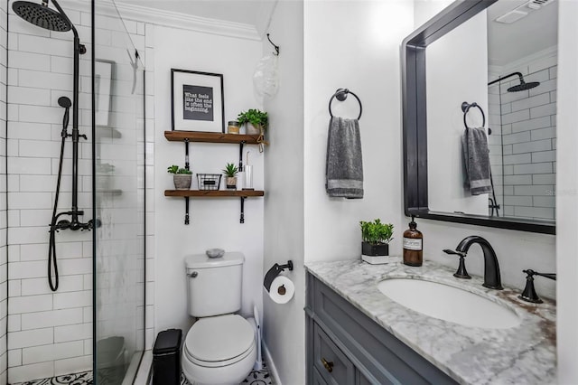 bathroom with crown molding, a tile shower, vanity, and toilet