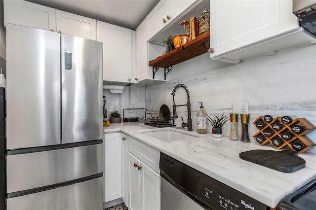 kitchen with stainless steel appliances, white cabinetry, sink, and tasteful backsplash