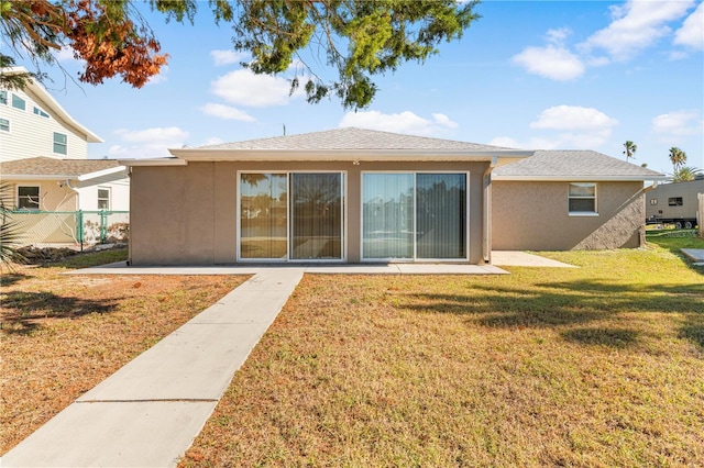 rear view of house with a lawn and a patio