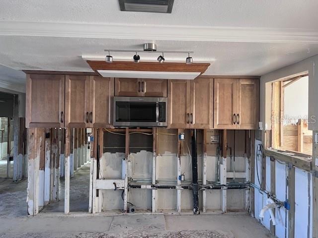 miscellaneous room with ornamental molding and a textured ceiling