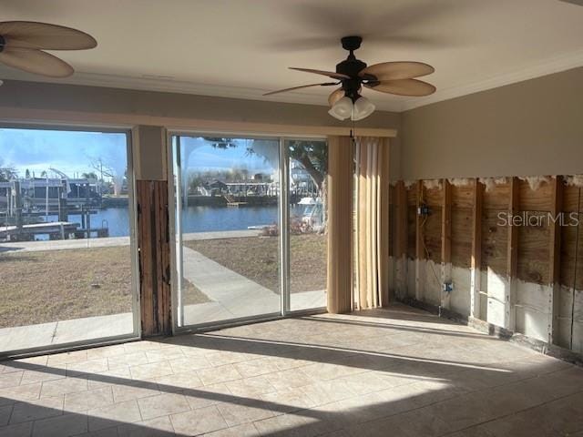 interior space featuring crown molding, ceiling fan, and a water view